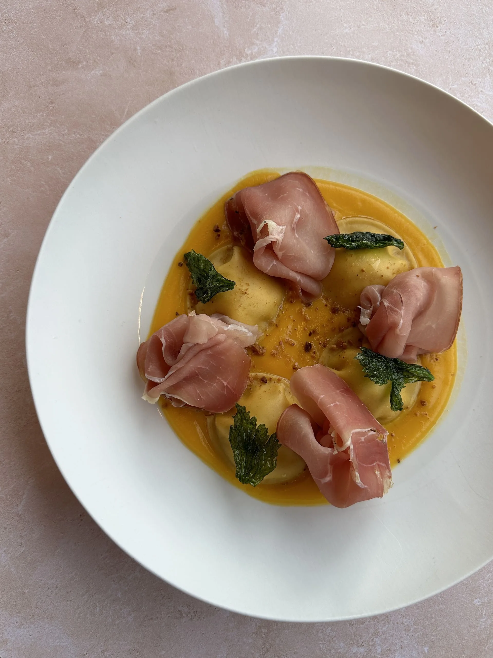 Ravioles de chèvre, jambon d’Ardenne, crème de butternut au curry et noisettes torréfiées