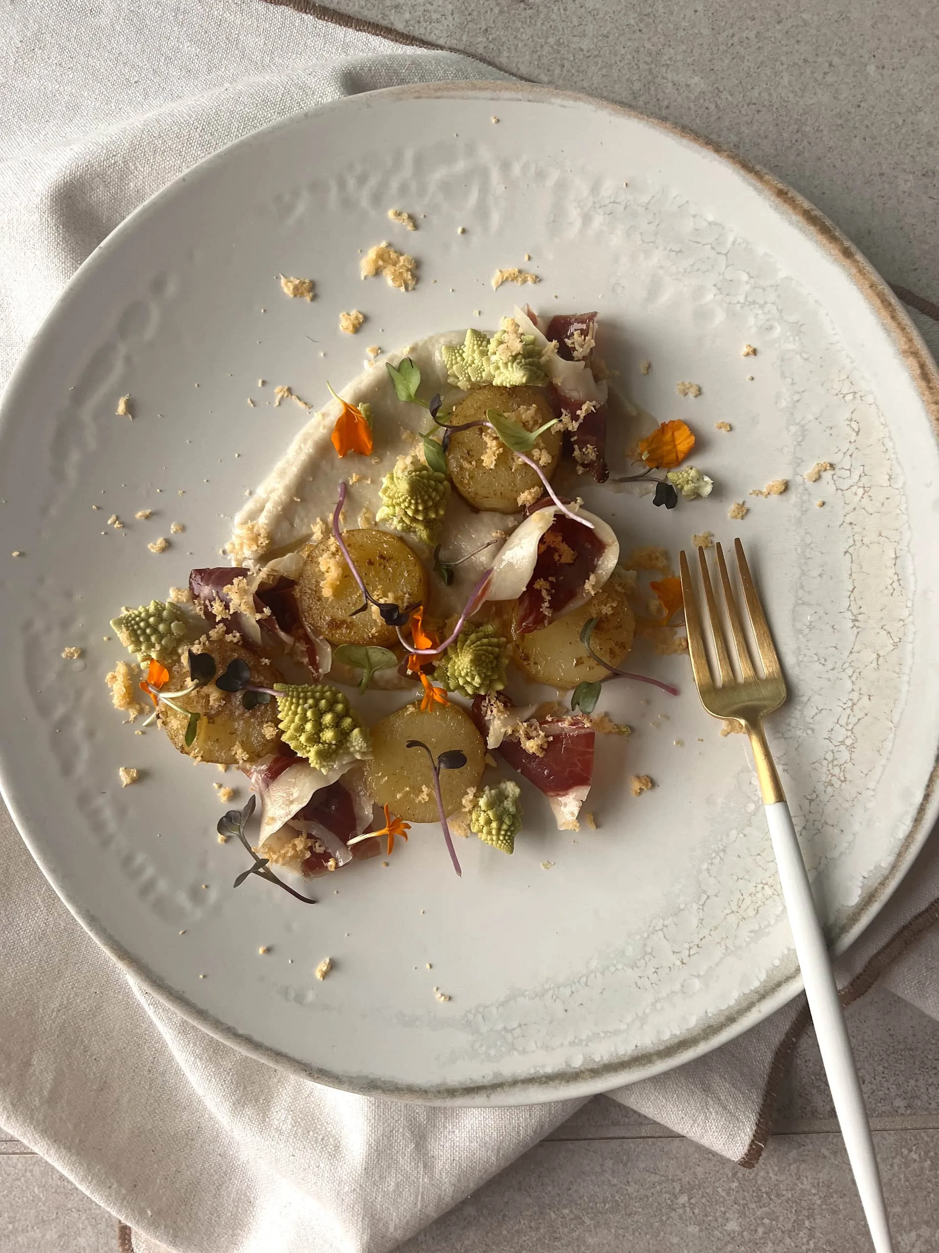 Palets de pommes de terre confits à l’ail noir, déclinaison de choux-fleurs et Bellota